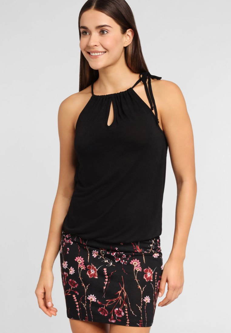 Blusa sin mangas negra con escote de ojal y tirantes atados, combinada con una falda negra ajustada con un patrón floral en rojo y rosa.