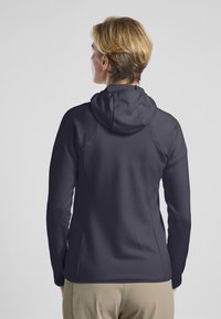 Giacca a foderato navy con finitura testurizzata, vestibilità slim e maniche lunghe. Il design presenta un colletto rialzato e spalle senza cuciture.