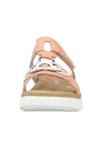 Sandale en cuir pêche avec un accent blanc et argent, ouverture à l'avant, sangle ajustable et semelle en caoutchouc texturée pour une meilleure adhérence.