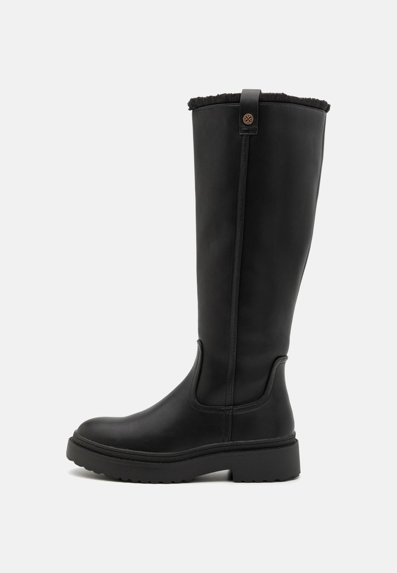 Botas negras hasta la rodilla hechas de cuero suave, con un ribete de piel de textura en la parte superior, suela de goma gruesa y detalles de costura en los laterales.