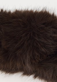 Primo piano di un tessuto in finto pelo marrone scuro, morbido e peloso, con una trama densa, soffice e filamenti sottili.