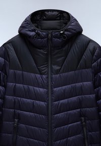 Marine blauwe pufferjack met een zwart paneelontwerp, uitgerust met een capuchon, ritssluiting en horizontale quilt voor isolatie. Geweven stofaccenten.
