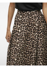 Gonna a stampa leopardata con cintura elastica, realizzata in tessuto leggero. Presenta una palette di colori in nero, marrone e beige, con pieghe.