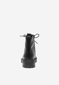 Bota negra de cuero hasta el tobillo con un acabado suave, detalle de cordones, cremallera trasera y una suela gruesa y texturizada negra.