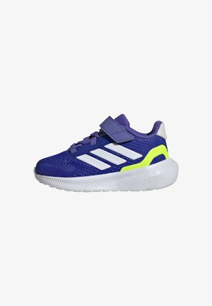 Zapatilla deportiva morada con rayas blancas y un acento verde neón. Cuenta con tela de malla, punta redondeada, cinta de velcro y suela texturizada.