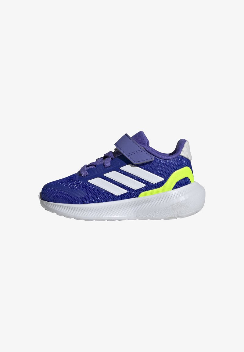 Zapatilla deportiva morada con rayas blancas y un acento verde neón. Cuenta con tela de malla, punta redondeada, cinta de velcro y suela texturizada.