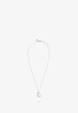 Collier en argent avec un pendentif circulaire plat orné d'un petit accent floral, suspendu à une chaîne fine à longueur réglable.