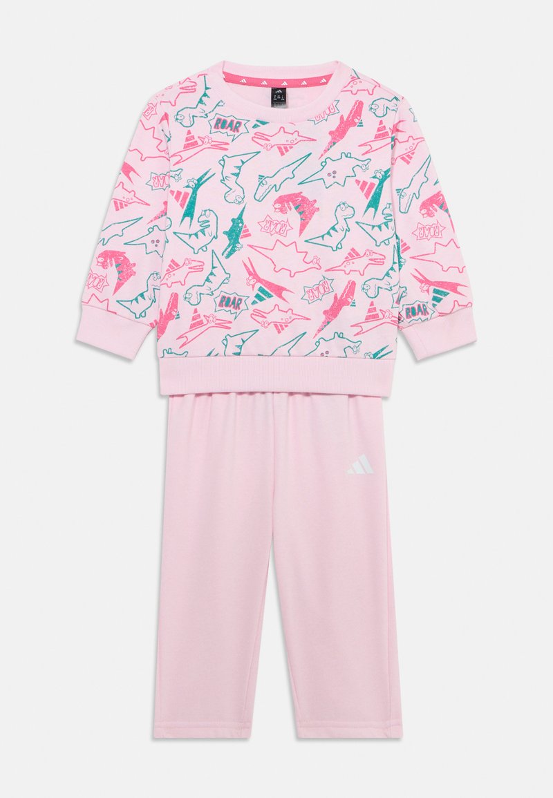 Sweatshirt rose et pantalon assorti avec un imprimé de dinosaure en vert et rose fluo. Tissu doux avec des poignets et une taille côtelés. Logo Adidas.