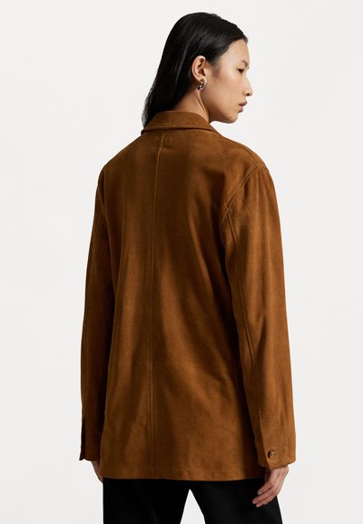 Giacca in suede marrone con colletto, vestibilità rilassata e maniche lunghe. Presenta un polsino abbottonato e una cucitura centrale che corre lungo la schiena.