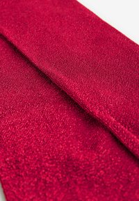 Czerwony materiał o błyszczącej teksturze, z delikatnym, tkanym wzorem. Materiał wydaje się miękki i ładnie się układa.
