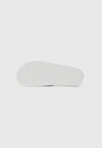 White rubber shoe sole with a hexagonal pattern and textured surface for grip. Smooth edges and rounded shape enhance the design.