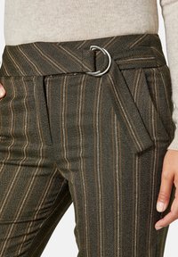Donkergroene gestreepte broeken met oranje lijnen, met een voorste sluiting en plooien voor extra textuur, gemaakt van lichtgewicht stof.
