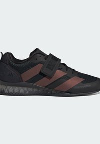 Czarne buty sportowe z oddychającą siateczką, kontrastującymi ciemnoczerwonymi paskami, rzepem i teksturowaną gumową podeszwą.