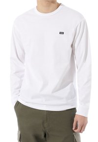 Weißes Langarmhemd aus Baumwolle mit rundem Ausschnitt, das ein kleines schwarzes Vans-Logo im linken Brustbereich trägt.