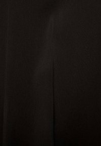 Tessuto nero che mostra una texture intrecciata, con una superficie liscia e una leggera lucentezza, arricchita da un dettaglio di cucitura verticale.