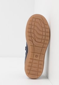 Námořnická sneaker podrážka s texturovaným gumovým povrchem. Obsahuje vlnité vzorky podrážky a zaoblenou špičku. Boční část boty ukazuje svrchní materiál.