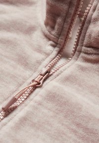 Lichtroze fleece hoodie met rits, met een gladde textuur, contrasterende rits met een ronde trekker en decoratieve stikselafwerking langs de naad.