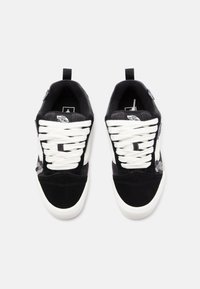 Black suede sneakers with white laces, padded collar, and floral design. Features a rubber sole and logo tag on the tongue.