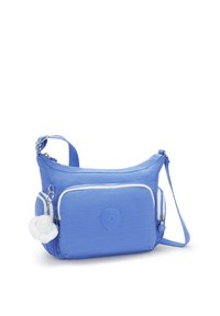 Light blue shoulder bag with a soft texture, featuring a front zip pocket, adjustable strap, and a fluffy charm attached.