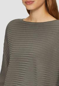 Gray ribbed sweater with a soft texture and wide neckline, featuring horizontal lines for a subtle pattern. Close-up view of the fabric.
