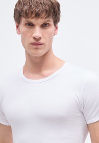 Witte katoenen T-shirt met een ronde hals en korte mouwen, met een gladde textuur en een aansluitend design.