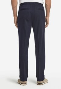 Marinblå, lätta byxor med elastisk midja, har två bakfickor och rak bendesign. Mjuk textur, minimala detaljer.