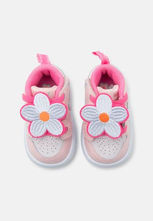 Rosa Kleinkind-Sneaker mit weißen Sohlen, verziert mit großen weißen Blumenapplikationen mit orangefarbenen Mittelpunkten auf den Riemen.