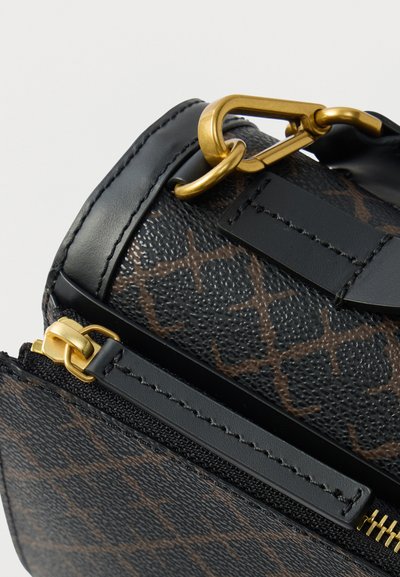 Μικρή τσάντα χειρός με υφασμάτινη μαύρη εξωτερική επιφάνεια, καφέ σχέδιο, χρυσά μεταλλικά στοιχεία και φερμουάρ. Διαθέτει δερμάτινο λουράκι και λεπτομέρεια κλεισίματος.