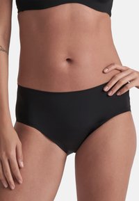 Bikini bottom nero a vita alta con una texture liscia e design senza cuciture, caratterizzato da un taglio a vita media per comfort e copertura.