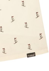 Bawełniana tkanina o jasnobeżowym tle z powtarzającymi się małymi ilustracjami narciarzy w kolorze białym i czerwonym, oznaczona etykietą "Pockies".