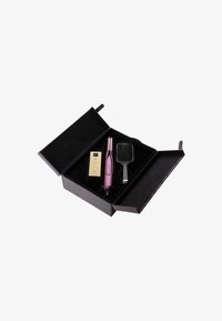 Haarstyling-Set in einer strukturierten schwarzen Box. Enthält ein pinkes Haarwerkzeug, eine schwarze Bürste und eine kleine Flasche mit Produkt. Innen mit schwarzem Stoff ausgekleidet.