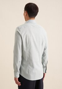 Lichtgroen overhemd met lange mouwen, met een button-down kraag, rechte snit en zichtbare stiksels op de mouwen en rug. Soepele textuur.