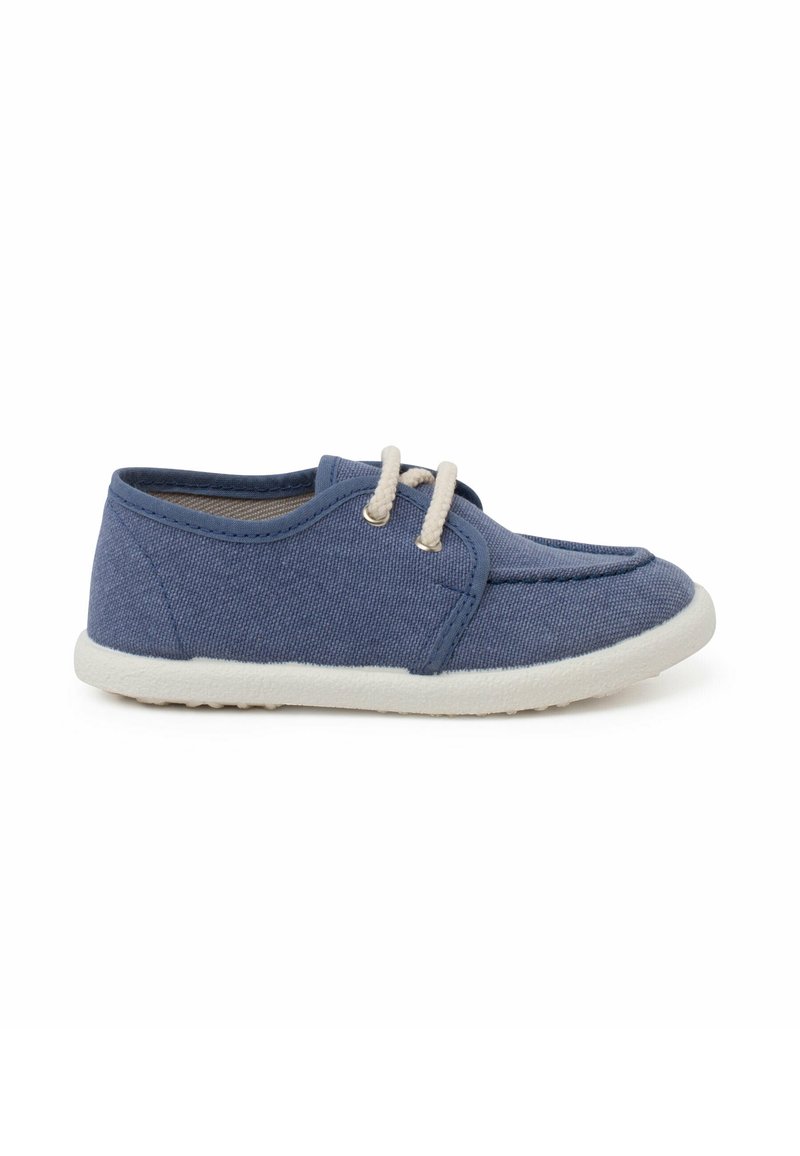 Chaussure en tissu bleu avec un bout arrondi, ornée de lacets beiges et d'une semelle en caoutchouc blanche. Partie supérieure texturée et éléments de design simples.