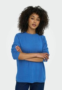 Blå stickad tröja med rund halsringning och trekvartslånga ärmar, med en avslappnad passform och ribbade muddar och nederkant.