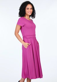 Fuchsia, knielanges Kleid mit kurzen Ärmeln, ausgestattet mit einem taillierten Oberteil, gerafftem Bund und zwei Seitentaschen. Glatter, elastischer Stoff.