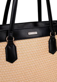 Zwarte en beige tote bag met een textuur van een geweven patroon, met leren handvatten en een metalen logo-accent. Gladde afwerking en gestructureerde vorm.