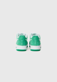 Green suede Nike Air sneakers with white accents. Features padded collar and tongue, textured rubber outsole, and debossed branding on heels.