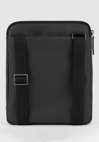 Zwarte leren tas met een gestructureerd oppervlak, voorzien van twee verticale banden en een ritssluiting aan de bovenkant. Minimalistisch ontwerp zonder versieringen.