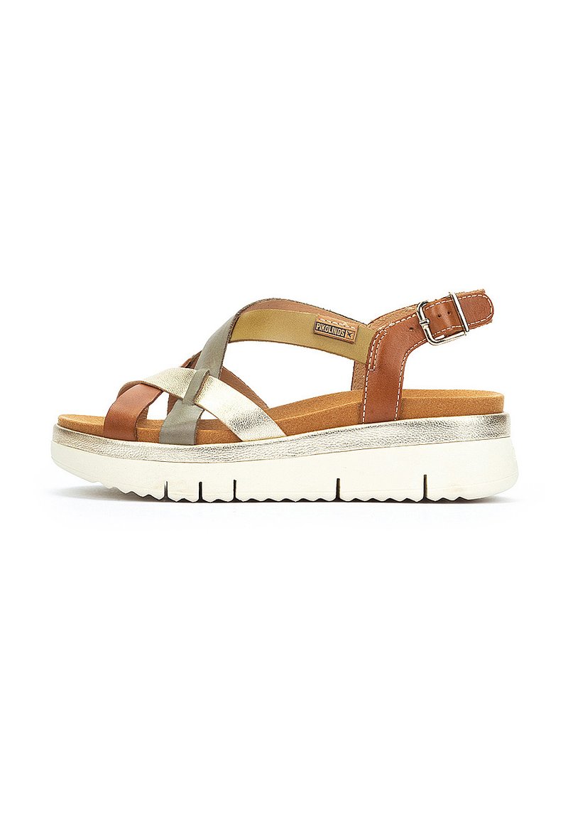 Sandalias de cuero marrón, dorado y plateado con correas cruzadas, correa de tobillo ajustable, plantilla acolchada y suela de plataforma blanca.