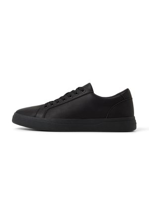Zapatillas negras de corte bajo con parte superior sintética suave, punta redonda, seis ojales y suela de goma con un patrón texturizado.
