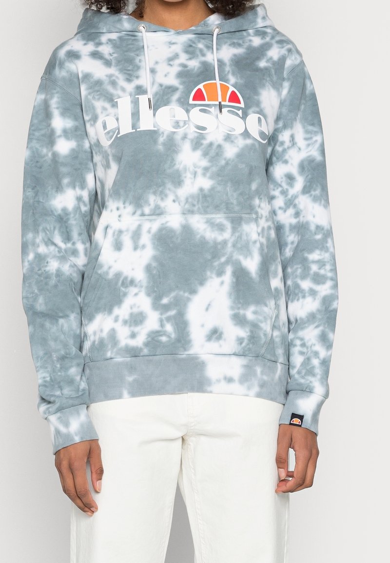 Szara bluza z kapturem w stylu tie-dye z białymi wzorami, wyposażona w przednią kieszeń kangurka i logo. Wykończona sznurkami i ściągaczami na rękawach.