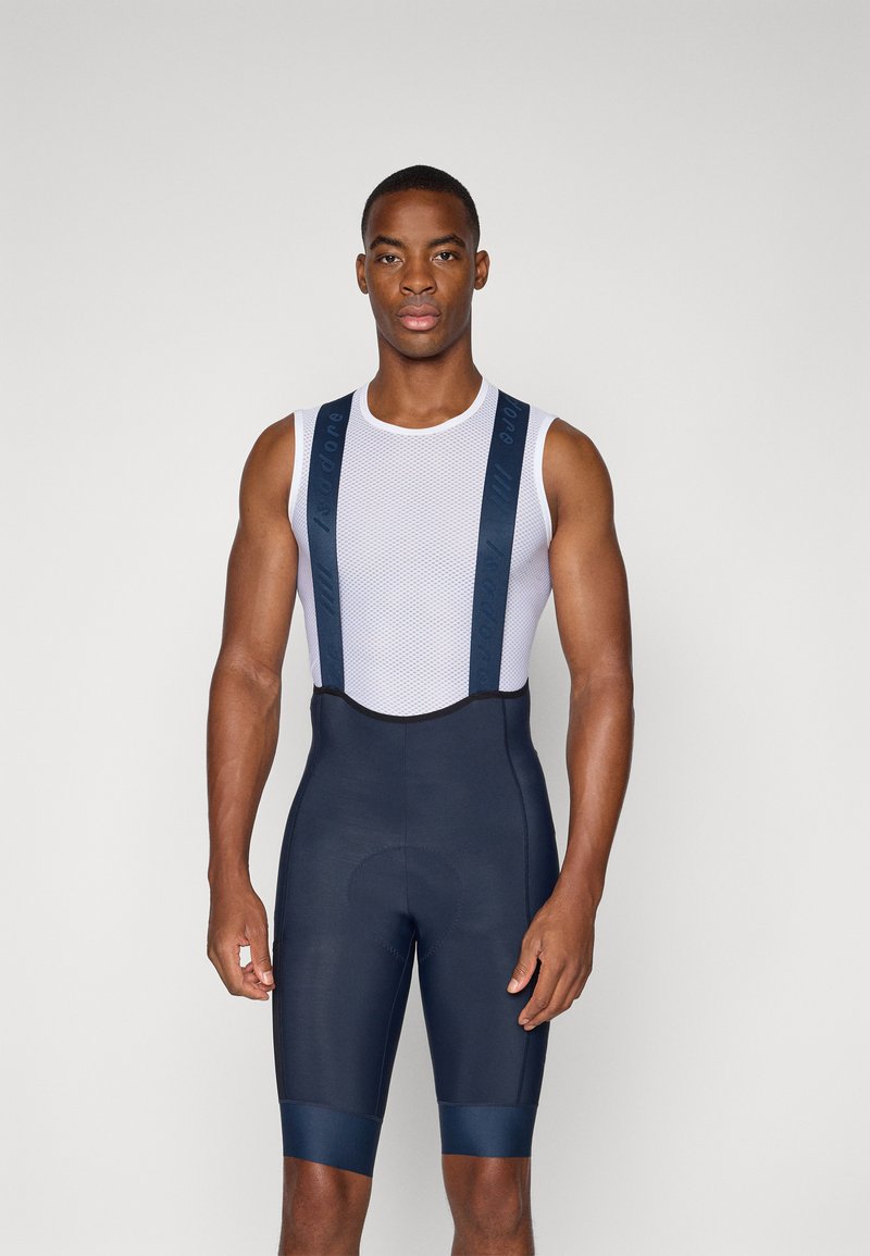 Pantalones cortos de ciclismo para hombres en navy con un top de malla blanca. Cuenta con tirantes anchos y un forro acolchado para mayor comodidad. Tejido suave y elástico.