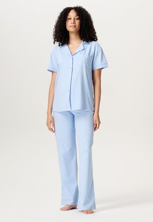 Lyseblåt pyjamas sæt lavet af blødt stof, med en kortærmet skjorte med krave og knaplukning samt matchende lige bukser med lomme.