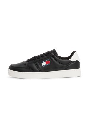 Czarny niskoprofilowy sneaker z białą podeszwą i łatką na pięcie, z logo Tommy Jeans w czerwonym, białym i niebieskim na bocznej części.