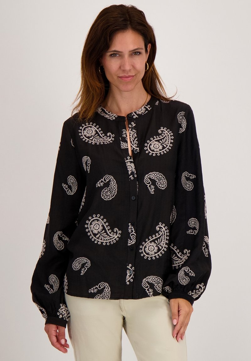 Zwarte blouse met lange mouwen, gekenmerkt door witte paisley patronen en een keyhole halslijn. Gemaakt van lichtgewicht stof met een ontspannen pasvorm.