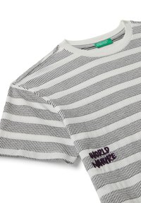 Camiseta blanca con rayas horizontales negras, con texto bordado en púrpura "MUNDO NATURAL", cuello redondo y mangas cortas.