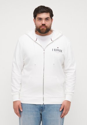 Hanorac alb cu fermoar, dotat cu un buzunar tip cangur, mansete cu nervuri și logo-ul Tommy Hilfiger pe piept. Include o glugă cu șnur și o textură netedă.