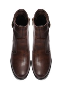 Stivaletti in pelle marrone con una finitura liscia, dotati di una cerniera laterale e un cinturino decorativo sull'esterno della caviglia.