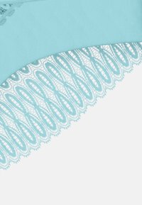 Jasnoniebieska tkanina z delikatną koronkową lamówką o kwiatowym wzorze, tworzącą teksturalny kontrast wzdłuż dolnej krawędzi.