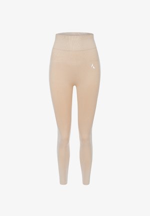 Šviesiai rudos spalvos aukštai kokybė leggings, pagaminti iš elastingos medžiagos, pasižymintys lygiu paviršiumi ir mažuoju baltu logotipu kairėje šlaunyje.